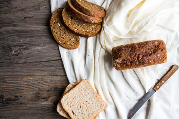 Assorted bread, slices of rye bread on linen tablecloths, wooden