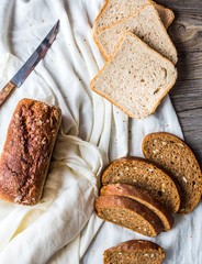 Assorted bread, slices of rye bread on linen tablecloths, wooden