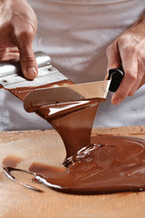 Cocinero preparando,mezclando crema de chocolate derretido.