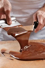Selbstklebende Fototapeten Cocinero preparando,mezclando crema de chocolate derretido. © Gustavo Andrade