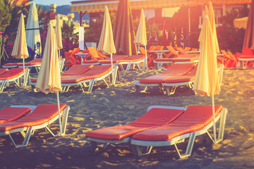 Umbrellas and beach chairs on the beach in sunlight.