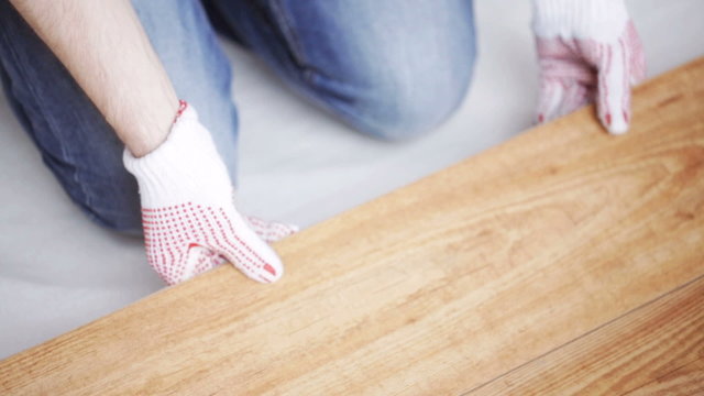 close up of man installing wood flooring