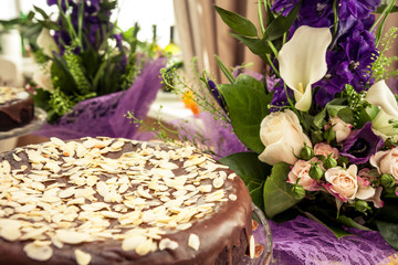 Luxury cake among flowers. Soft focus on pie’s leading edge