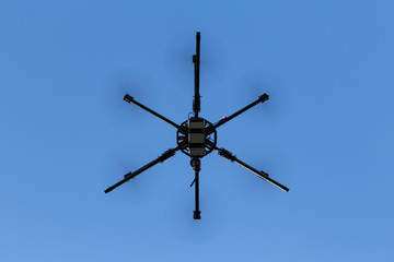 Professional drone hexacopter flying on blue sky