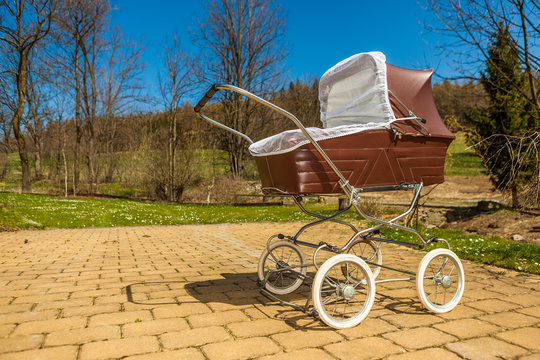 Retro style baby carriage outdoors on sunny day
