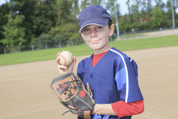 A child baseball pitchen on the field