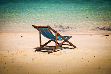 Exotic beach holiday background with white hate on beach chair