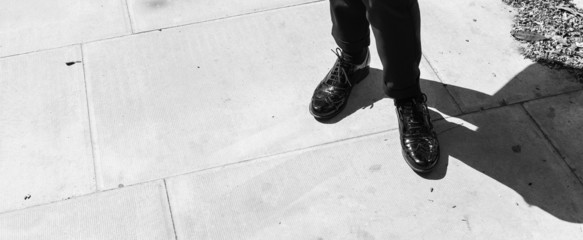 Focus on woman legs wearing London style black leather brogues