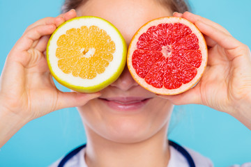 Nutritionist covering her eyes with fruits