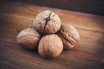 Walnut kernels and whole walnuts wood background