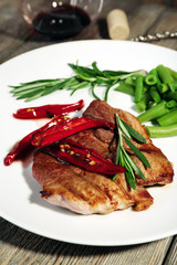Steak with vegetables on plate on table close up