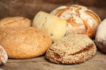 Different fresh bread on old wooden table