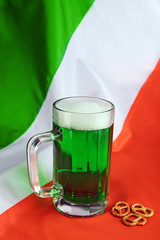 Glass of green beer on Ireland flag background