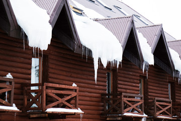 Naklejka premium Wooden building with icicles on roof, outdoors