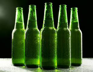 glass bottles of beer on dark background
