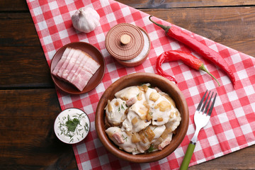 Tasty dumplings with fried onion in brown bowl,