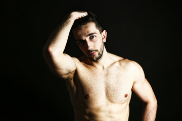 Fototapeta premium Muscle young man on black background