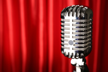 Retro silver microphone on red fabric background