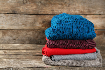 Knitting clothes on wooden background