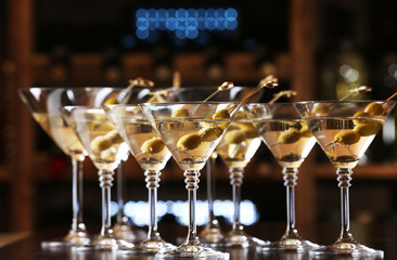 Glasses of cocktails on bar background