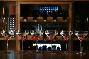 Glasses of cocktails on bar background