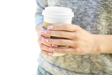 Female hands with paper cup of coffee outdoors, closeup