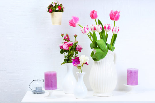 Beautiful composition with different flowers in vases