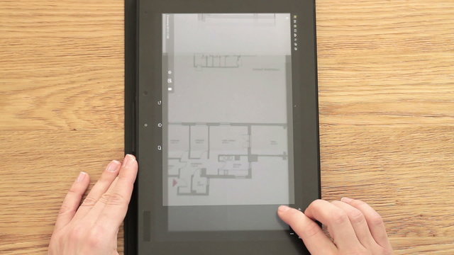 Architect analyzing blueprint on digital tablet, top view