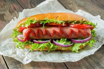 Hot dog with lettuce, tomato and onion