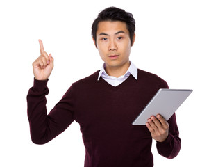 Fototapeta na wymiar Asian businessman look at digital tablet and finger point up