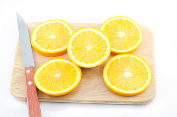 Pieces of Orange and knife on a cutting wooden board