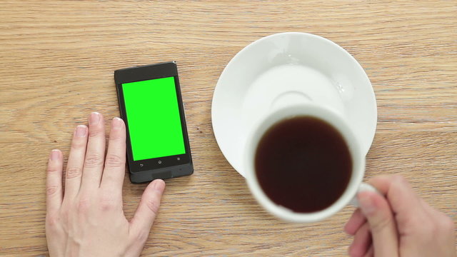 Smartphone with isolated green screen on wooden table