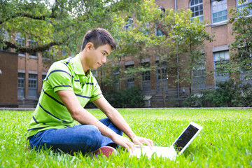 Young male college student sitting use laptop at campus 