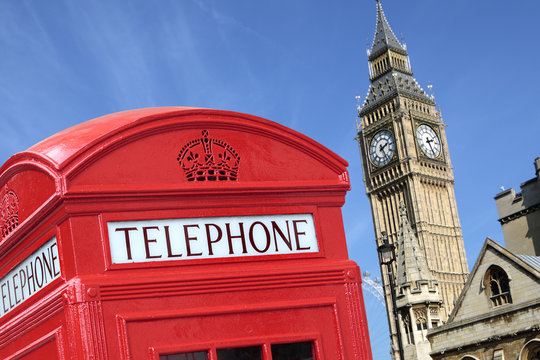 London red telephone box booth with westminster british houses of parliament building and Big Ben clock tower in the background photo