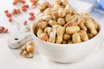Peanuts in shells in a    white bowl.