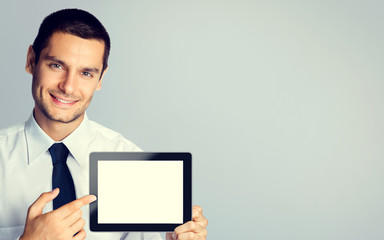 Young businessman showing blank tablet pc