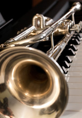 Trumpet segment closeup lying on piano keys