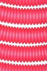 Red plastic corrugated pipe on white background