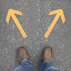 Pair of shoes on a road with arrow