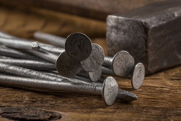 Vintage hammer with nails on wood background