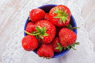 Fresh strawberries in a small blue bowl