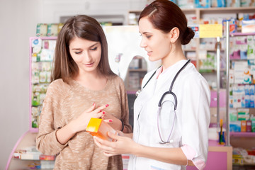 Woman doctor and client inside pharmacy