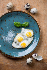 Turquoise plate with fried quail eggs, view from above