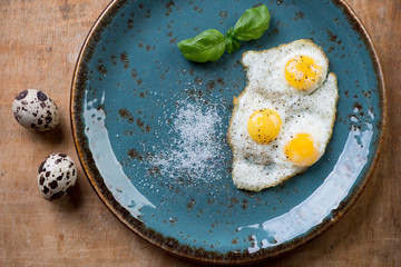 Breakfast with fried quail eggs, view from above, studio shot