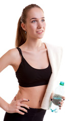 Cute teenager girl with towel on shoulder and bottle in hands