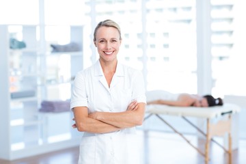 Physiotherapist smiling at camera arms crossed