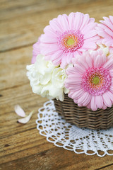 Fototapeta na wymiar Bouquet of pink gerberas on wooden table
