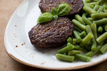 Close-up of beef cutlets and beans, selective focus, studio shot