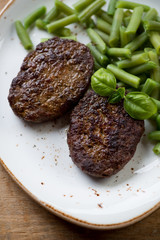 Beef cutlets with beans, close-up, above view