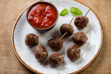 Meatballs on skewers with dipping sauce, close-up, studio shot